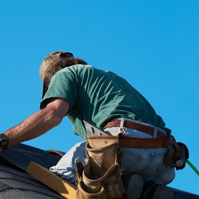 roofer installing asphalt shingle roofing