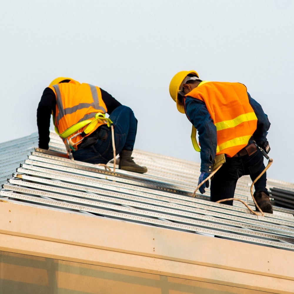 Two roofers installing insulation