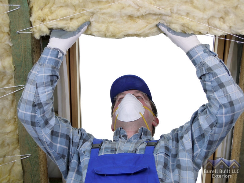 A Picture of a Man Wearing a Mask While Installing Insulation.